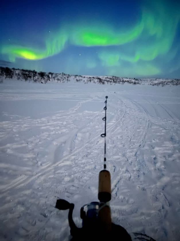 Ice fishing under the northern lights