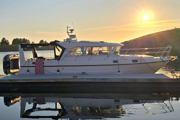 Boat in habor with sun in background