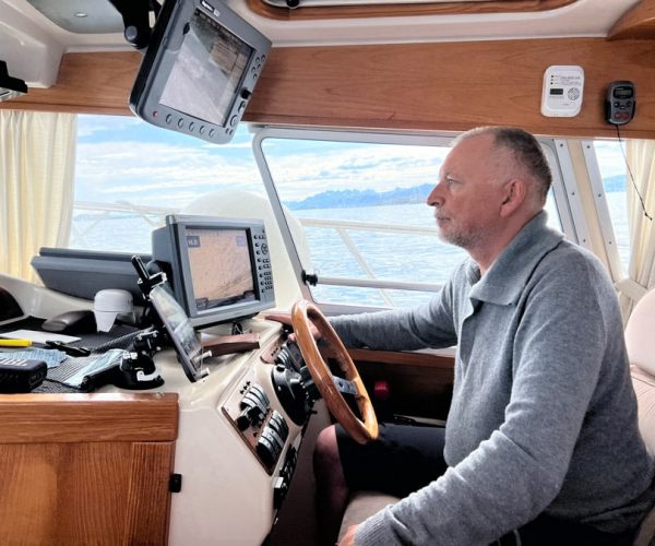Captain Jørn driving boat inside cabin