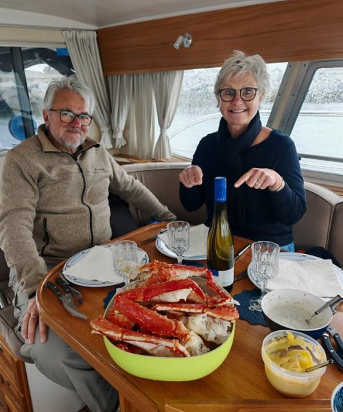 midaged couple excited for king crab lunch on board