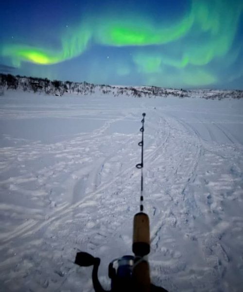 Ice fishing under the northern lights