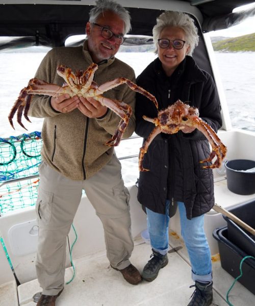 Couple holding up king crabs